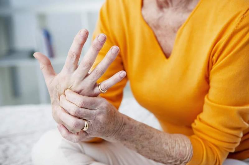 Osteoarthritis patient rubbing hands in pain. Consultations available at Narangba Station Medical Centre to manage symptoms of Osteoarthritis.