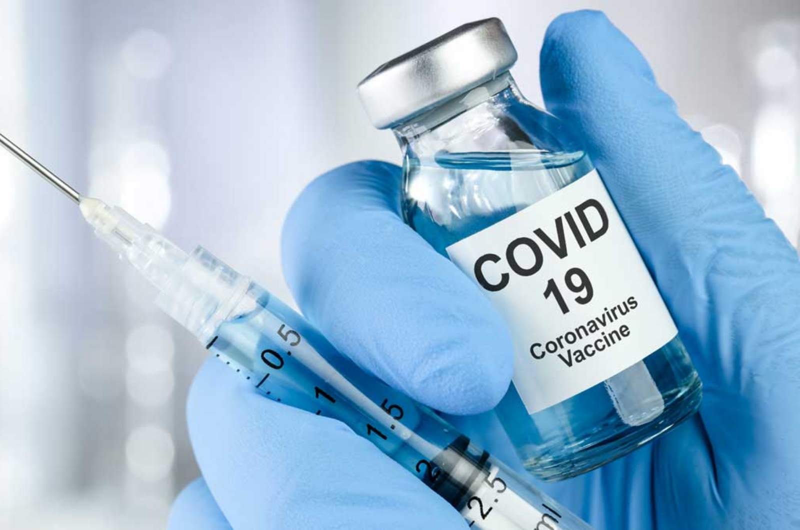 A nurse holding Covid-19 Vaccination in hand.