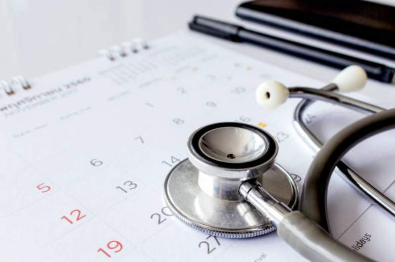 Doctors stethoscope lying on calendar representing annual preventive health checks