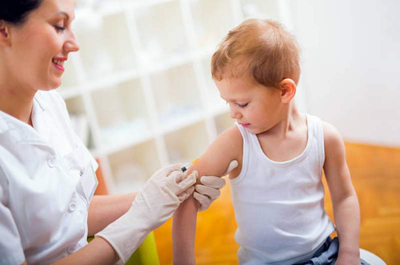 Child receiving diphtheria vaccination by nurse.