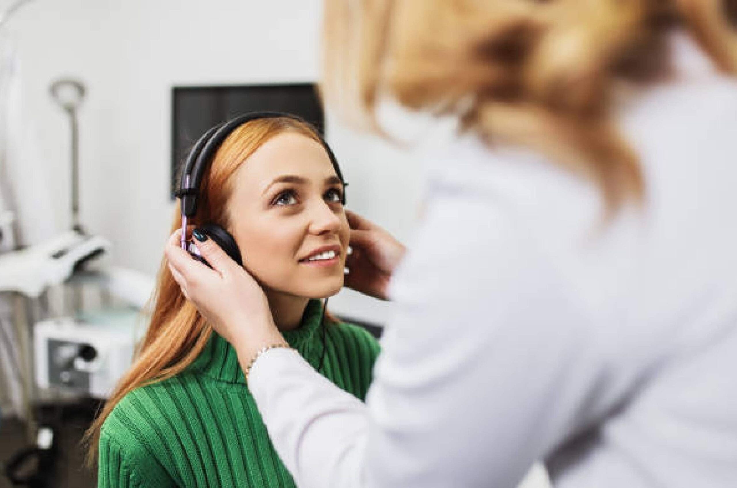Audiologist-performing-hearing-test-on-patient Audiologist performing hearing test on patient.
