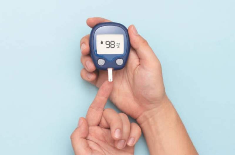 Diabetes-care-blood-test Individual measuring glucose levels with finger prick blood test to manage diabetes.