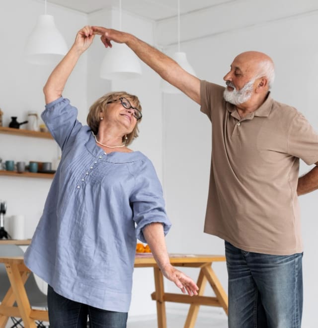 Plant Based Medicine & Plant Based Therapies - A happy elderly couple smile at each other as the man spins his wife, dancing together.