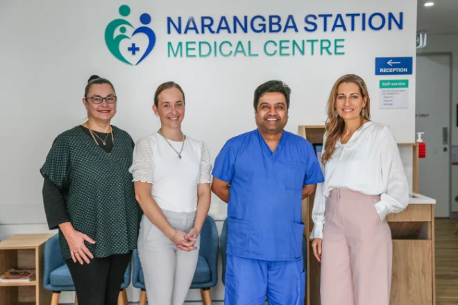 Dr Madhu Lakshmaiah and his team standing and smiling in front of Narangba Station Medical Centre sign - open 7 days and after hours appointments available.